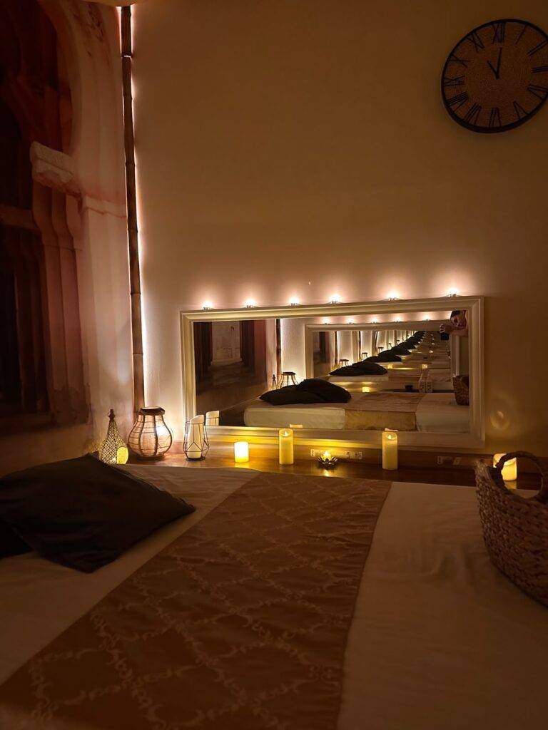 Massage room with mirror and a row of candles in Marbella