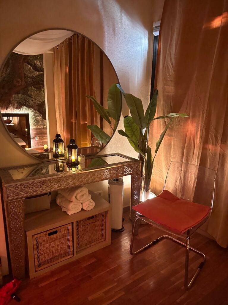 Round mirror, plant and candlelit table at Tantra Marbella