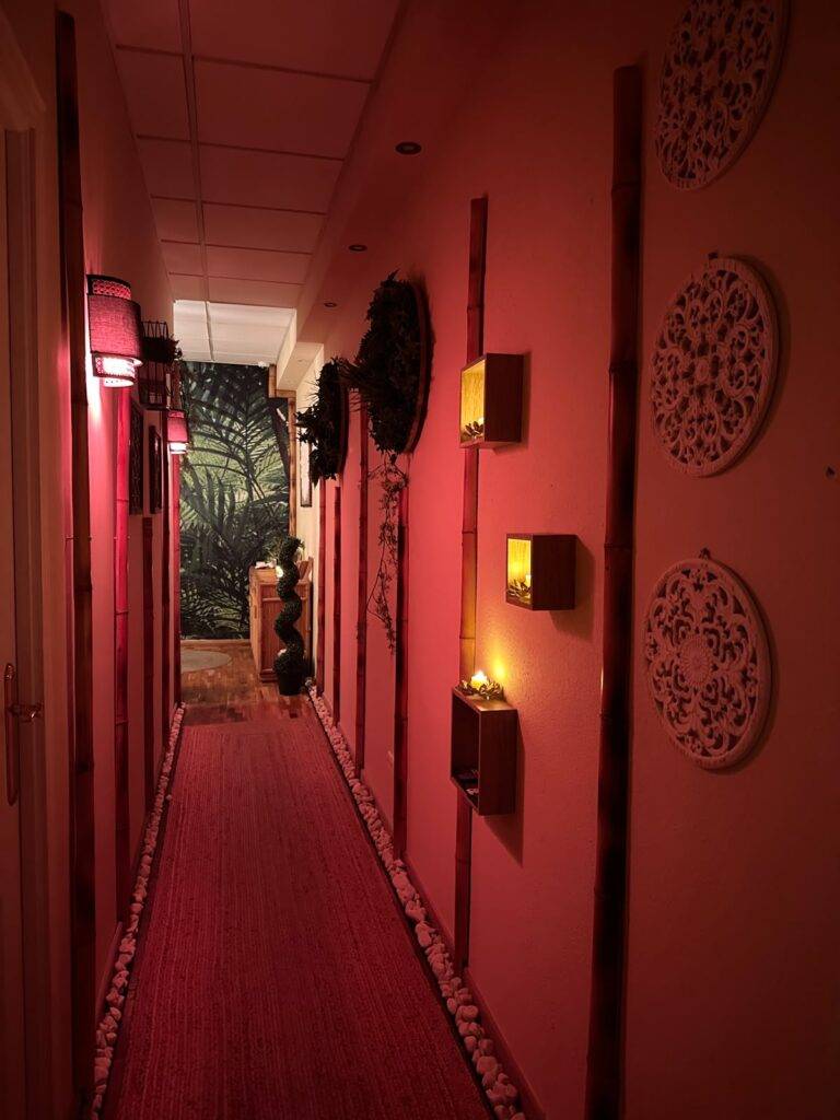 Warm red candlelit corridor at our Marbella tantric massage centre